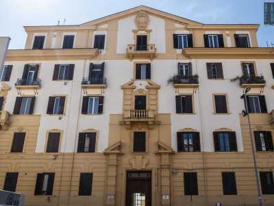 La dimora si innalza su cinque piani scanditi da una sequenza parallela di finestre con imposte marroni...